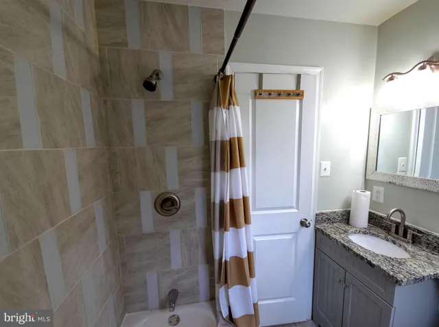 a bathroom with a granite countertop sink toilet and shower