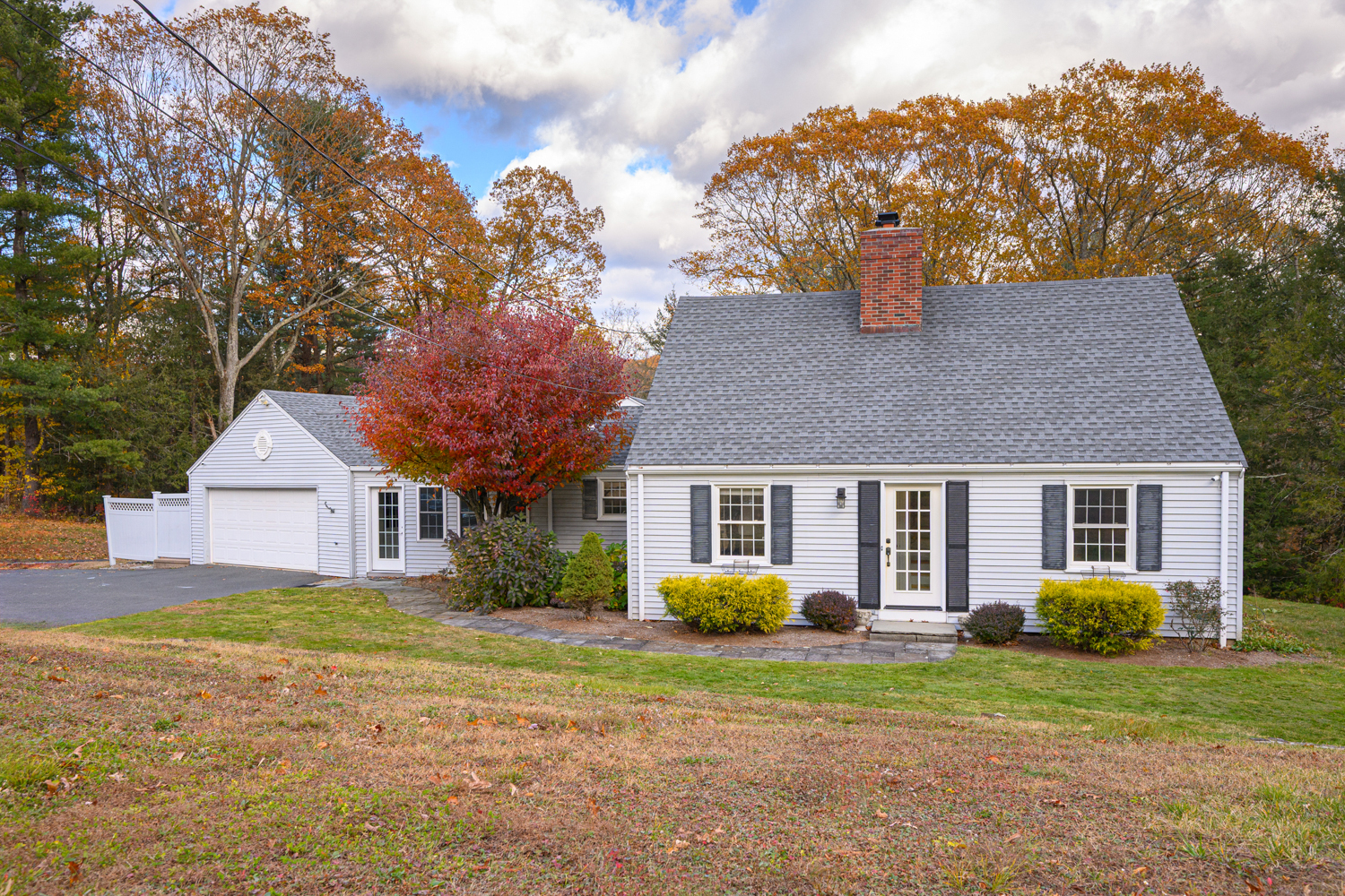a front view of a house with a yard and trees
