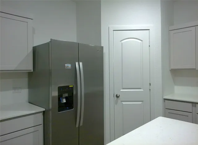 a kitchen with a refrigerator and cabinets