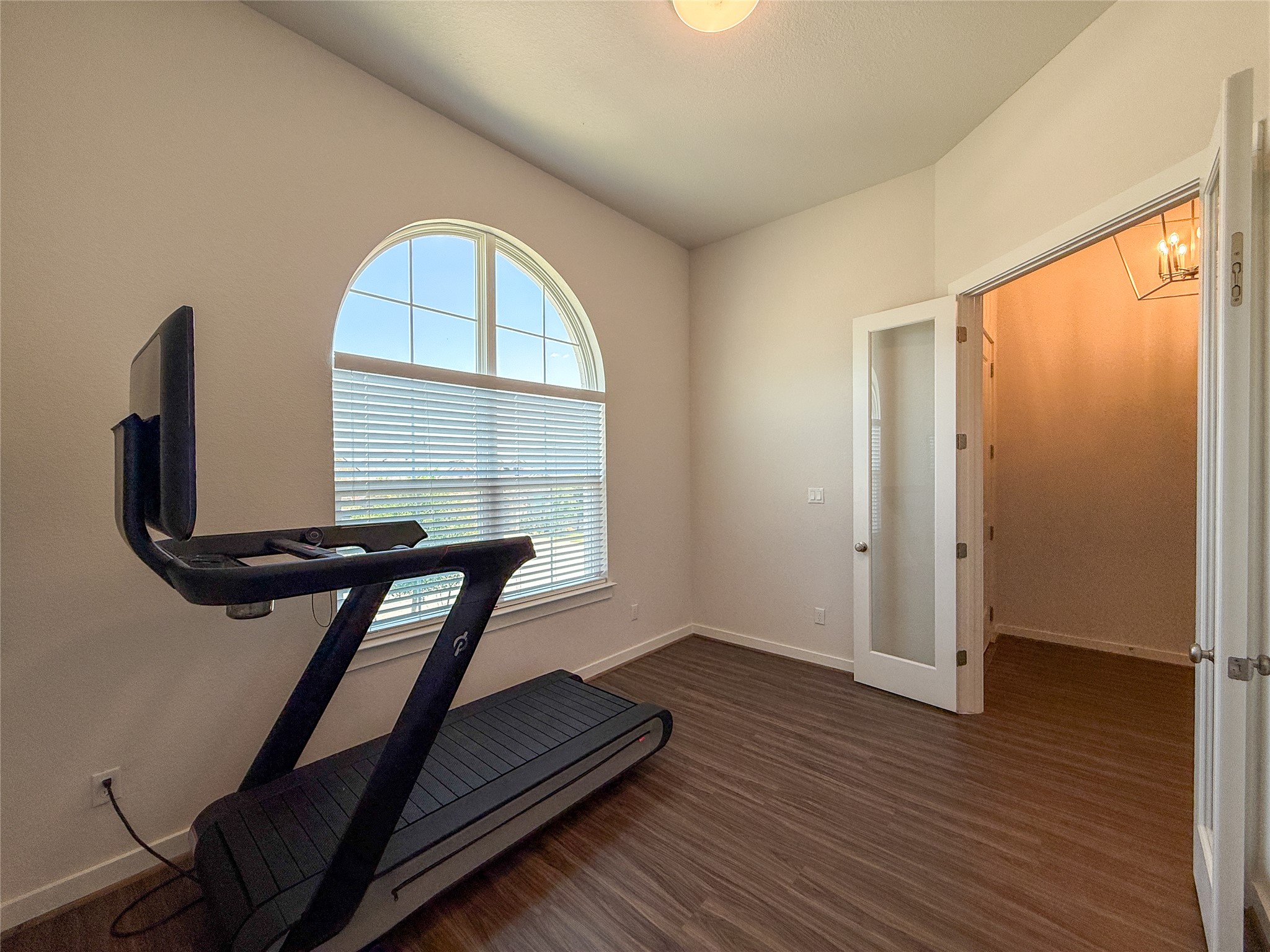 249 Heartleaf Road San Marcos, TX 78666 - Photo 6 of 38 Natural light floods this versatile space, featuring rich hardwood flooring and an arched window.