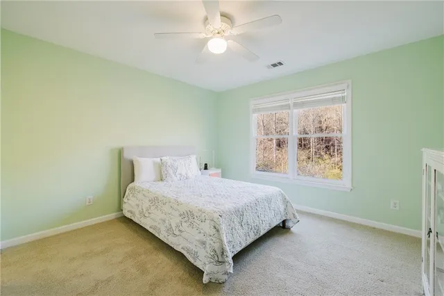 a front view of a house with a garden and lake view