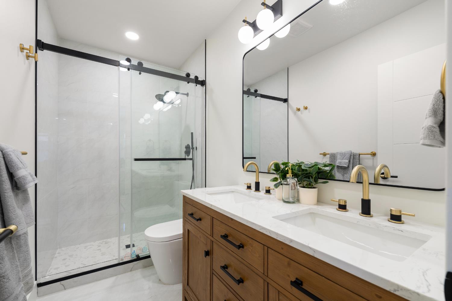 5401 J Street Sacramento, CA 95819 - Photo 31 of 71 a bathroom with a double vanity sink toilet mirror and shower