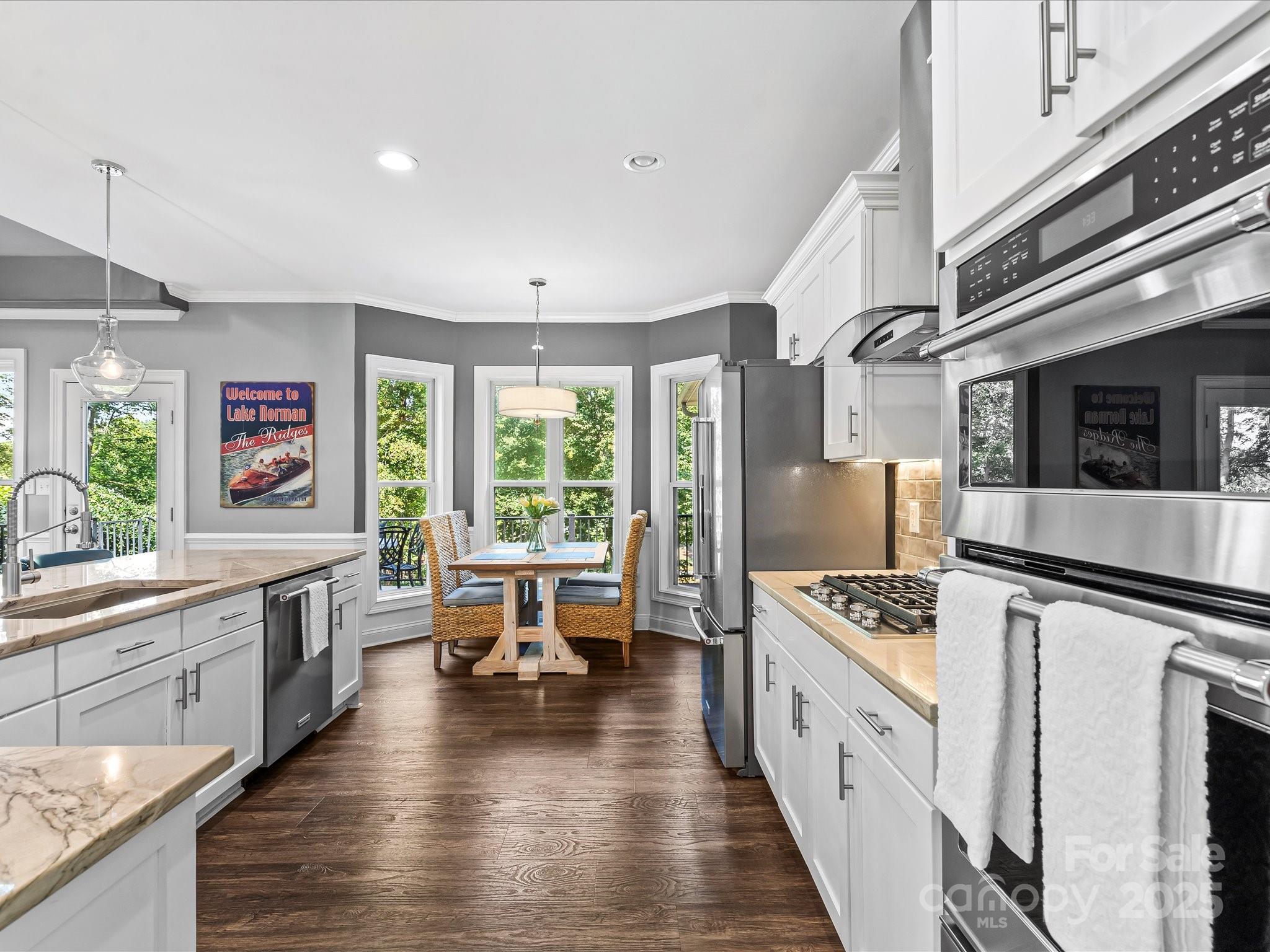 172 Beaten Path Road Mooresville, NC 28117 - Photo 11 of 48 a kitchen with stainless steel appliances a stove top oven a sink a refrigerator white cabinets and wooden floor