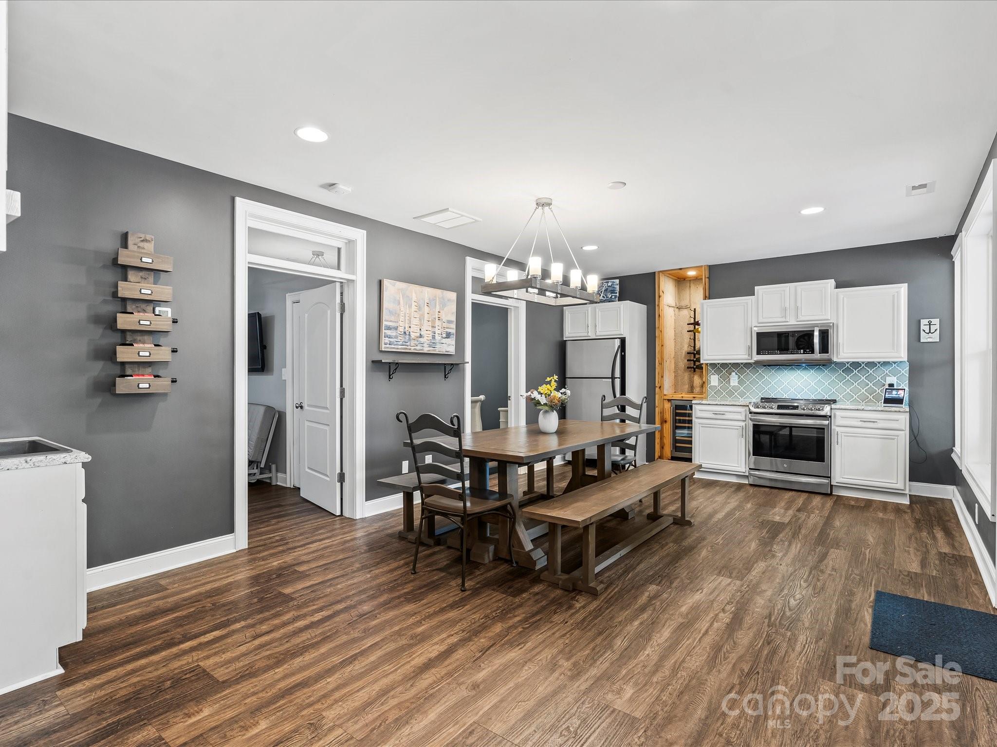 172 Beaten Path Road Mooresville, NC 28117 - Photo 33 of 48 a kitchen with stainless steel appliances a dining table chairs stove refrigerator and cabinets