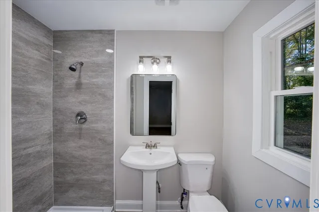 a bathroom with a toilet a sink and mirror