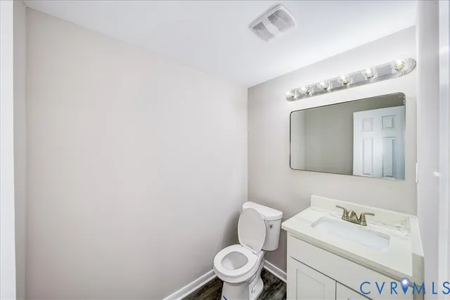 a bathroom with a toilet sink vanity and mirror