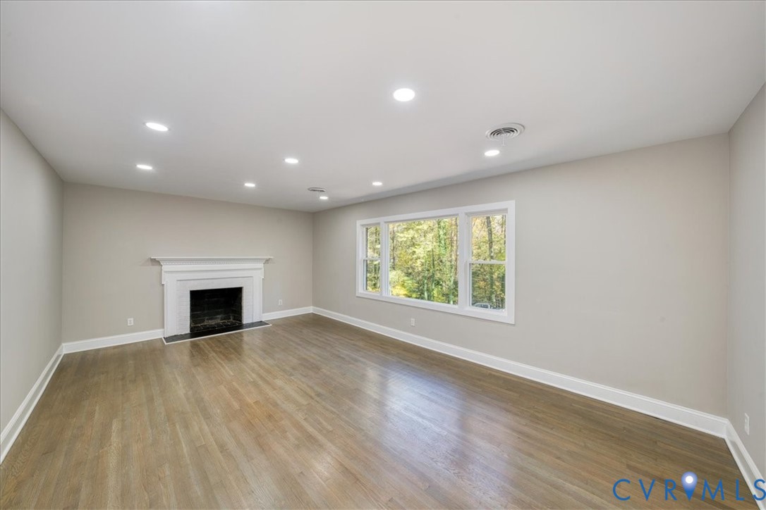 3600 Sherbrook Road Richmond, VA 23235 - Photo 5 of 26 an empty room with wooden floor fireplace and windows