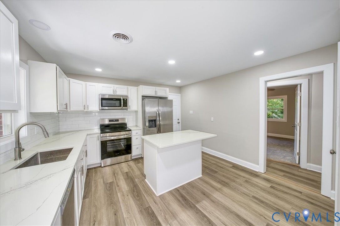 3600 Sherbrook Road Richmond, VA 23235 - Photo 8 of 26 a kitchen with stainless steel appliances a stove a sink a refrigerator white cabinets and wooden floor