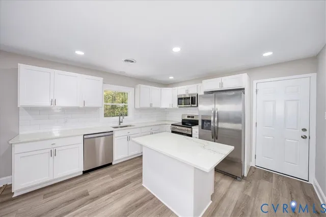 a kitchen with white cabinets and stainless steel appliances