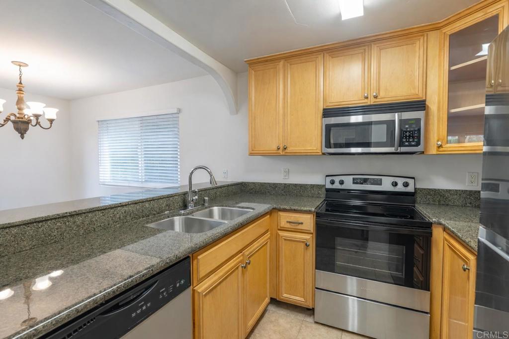 1145 Helix Street, Unit 13 Spring Valley, CA 91977 - Photo 5 of 12 a kitchen with granite countertop a sink stainless steel appliances and cabinets