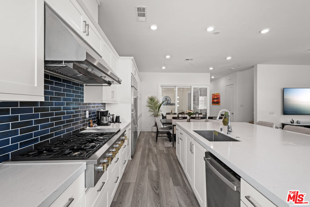 26710 Beartown Lane Stevenson Ranch, CA 91381 - Photo 3 of 21 a kitchen with lots of counter top space a sink and stainless steel appliances