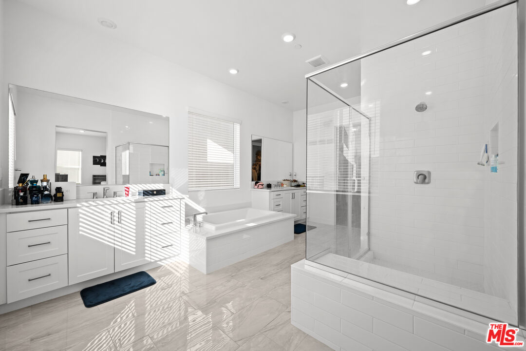 26710 Beartown Lane Stevenson Ranch, CA 91381 - Photo 9 of 21 a bathroom with a bathtub a mirror a vanity and a shower