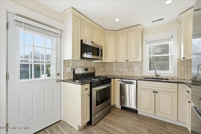 a kitchen with stainless steel appliances granite countertop a stove a refrigerator and a sink