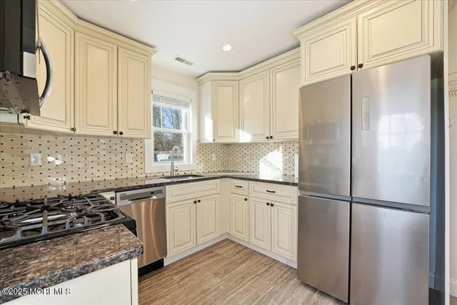 a kitchen with stainless steel appliances granite countertop a stove top oven microwave and refrigerator