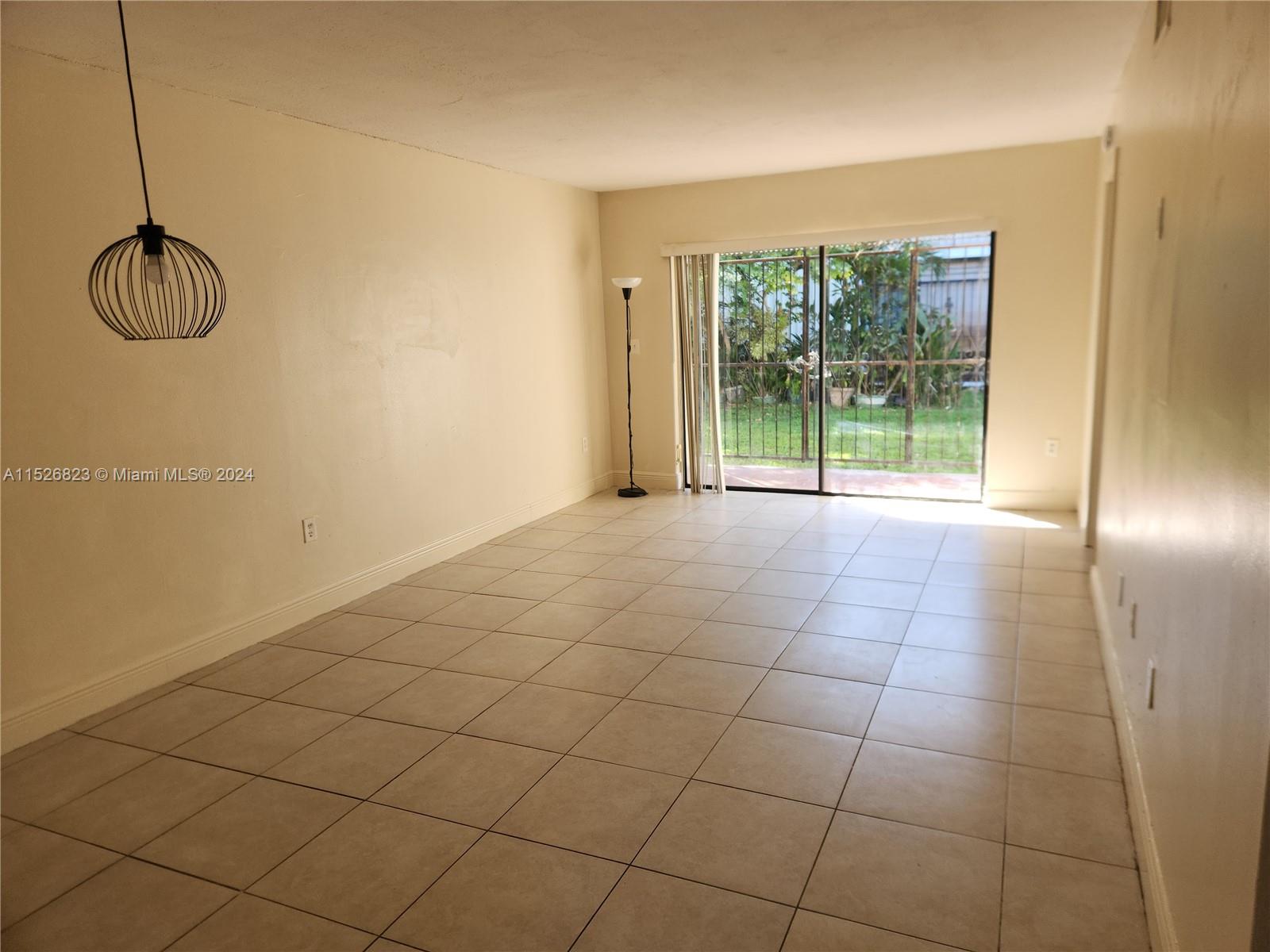 6259 West 24th Avenue, Unit 1028 Hialeah, FL 33016 - Photo 1 of 22 a view of a room with sliding glass door