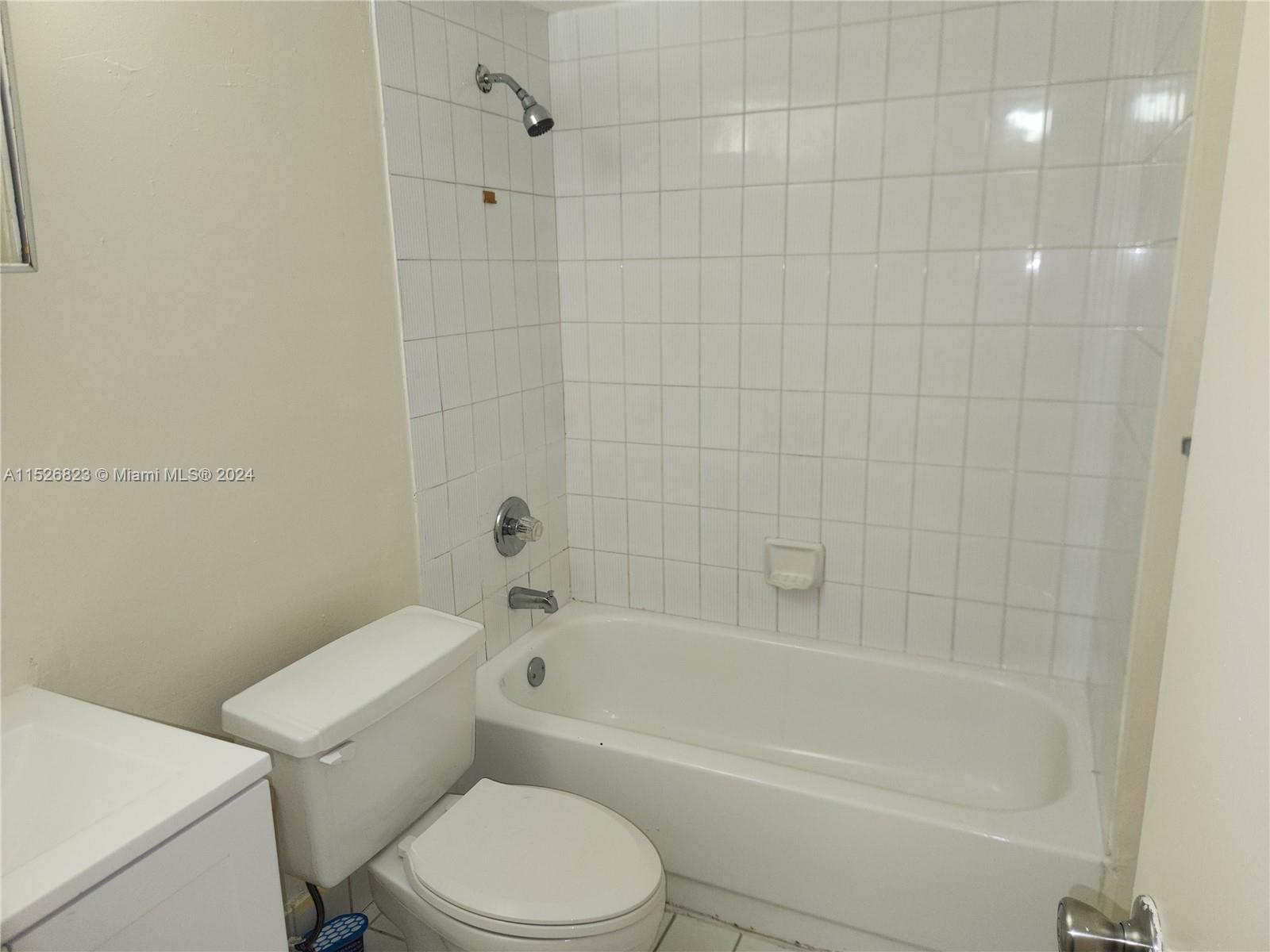 6259 West 24th Avenue, Unit 1028 Hialeah, FL 33016 - Photo 11 of 22 a white toilet and tub sitting next to a bathroom sink