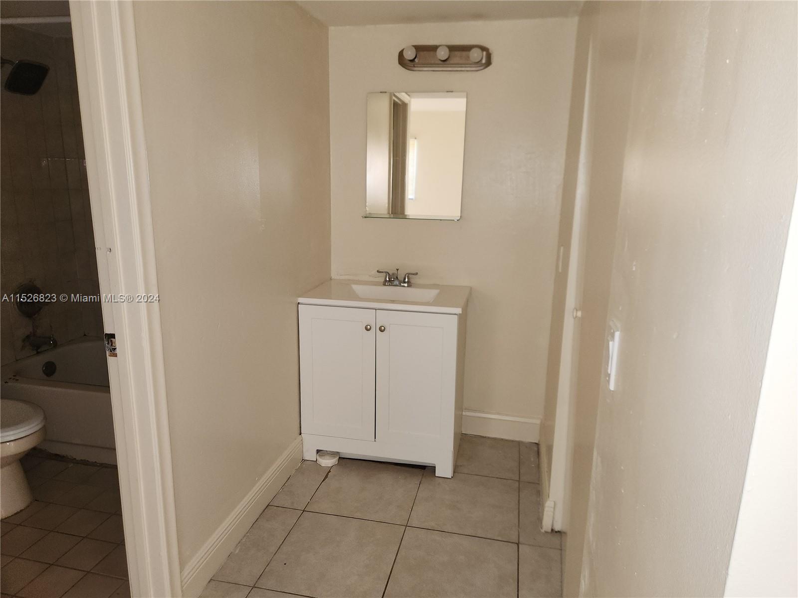 6259 West 24th Avenue, Unit 1028 Hialeah, FL 33016 - Photo 17 of 22 a bathroom with a toilet sink and mirror