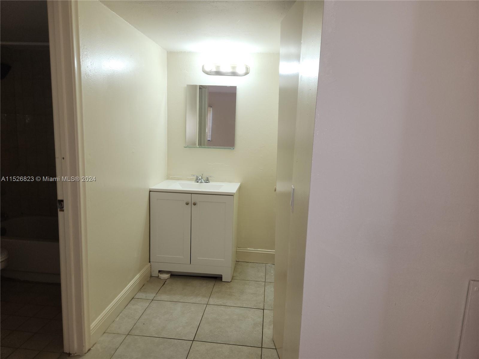 6259 West 24th Avenue, Unit 1028 Hialeah, FL 33016 - Photo 18 of 22 a bathroom with a sink and a mirror