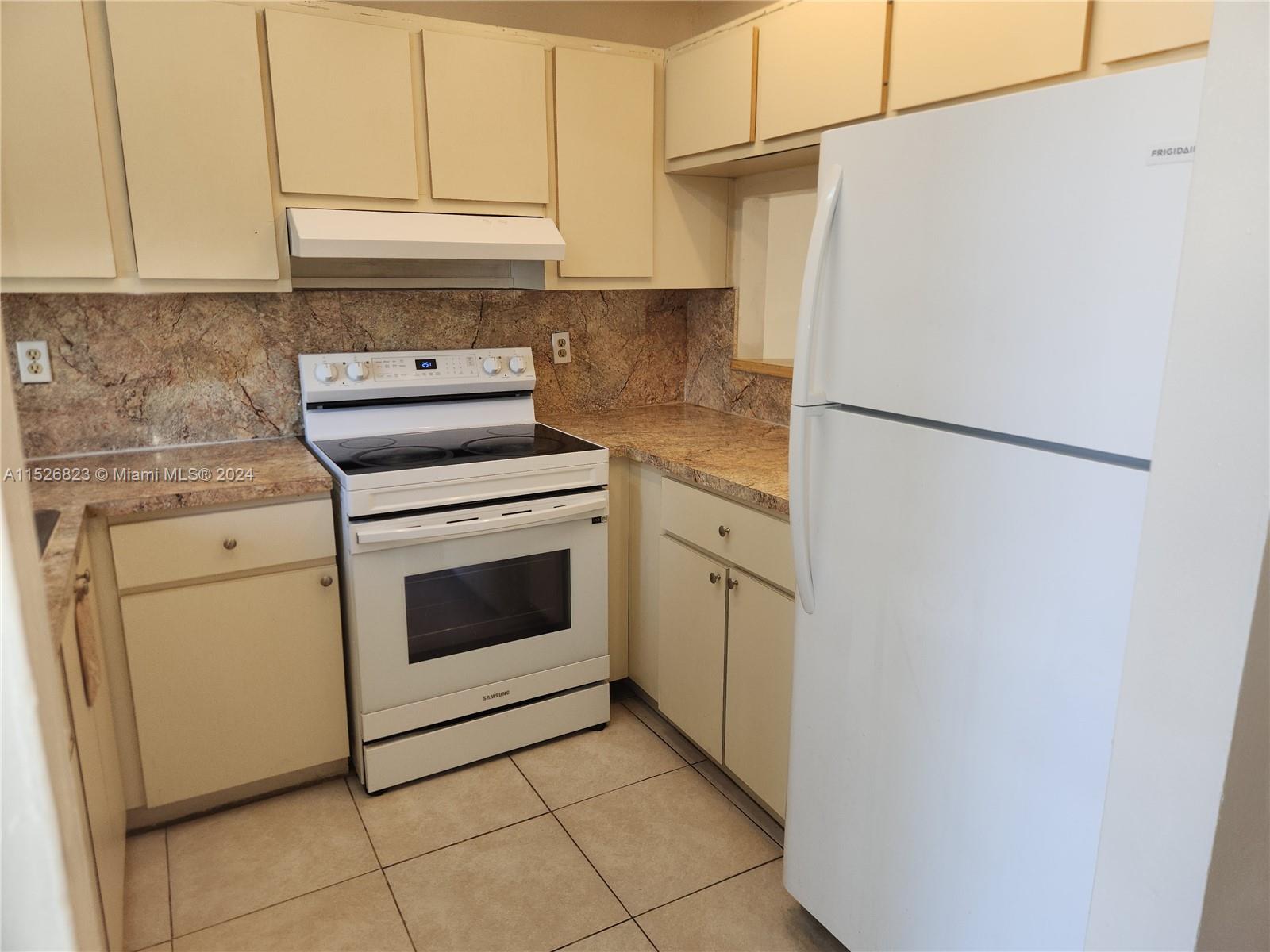 6259 West 24th Avenue, Unit 1028 Hialeah, FL 33016 - Photo 9 of 22 a kitchen with a stove top oven and cabinets
