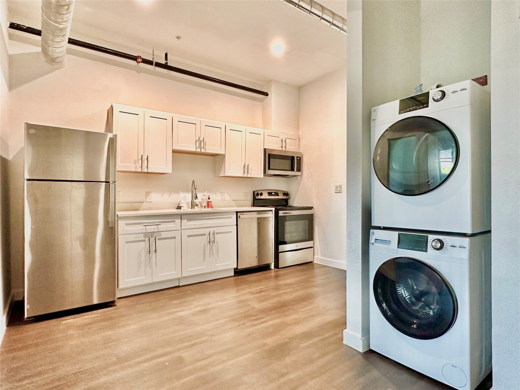 a kitchen with cabinets washer and dryer