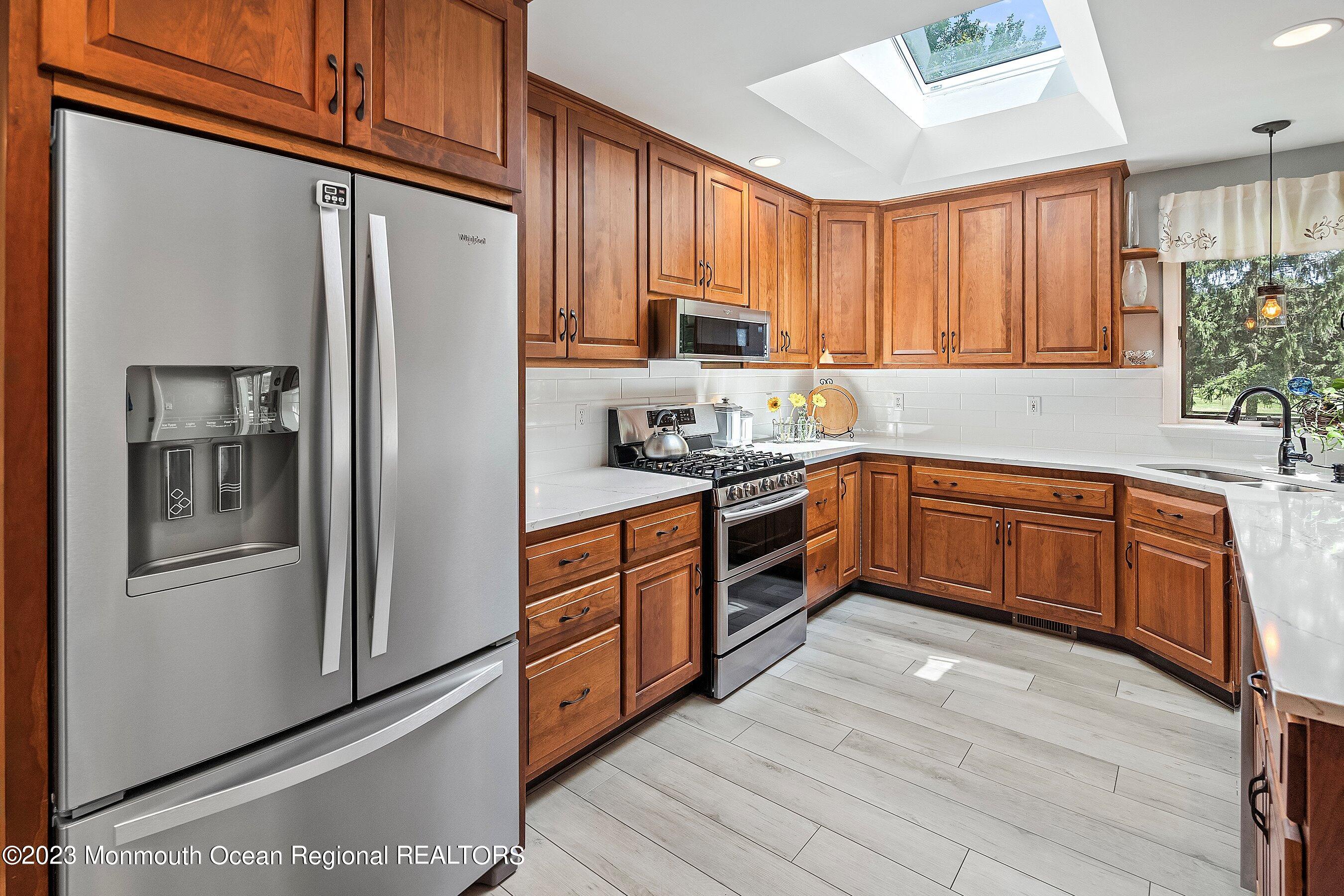 146 Peskin Road Farmingdale, NJ 07727 - Photo 12 of 31 a kitchen with stainless steel appliances granite countertop a refrigerator a sink dishwasher a refrigerator with wooden cabinets and floor