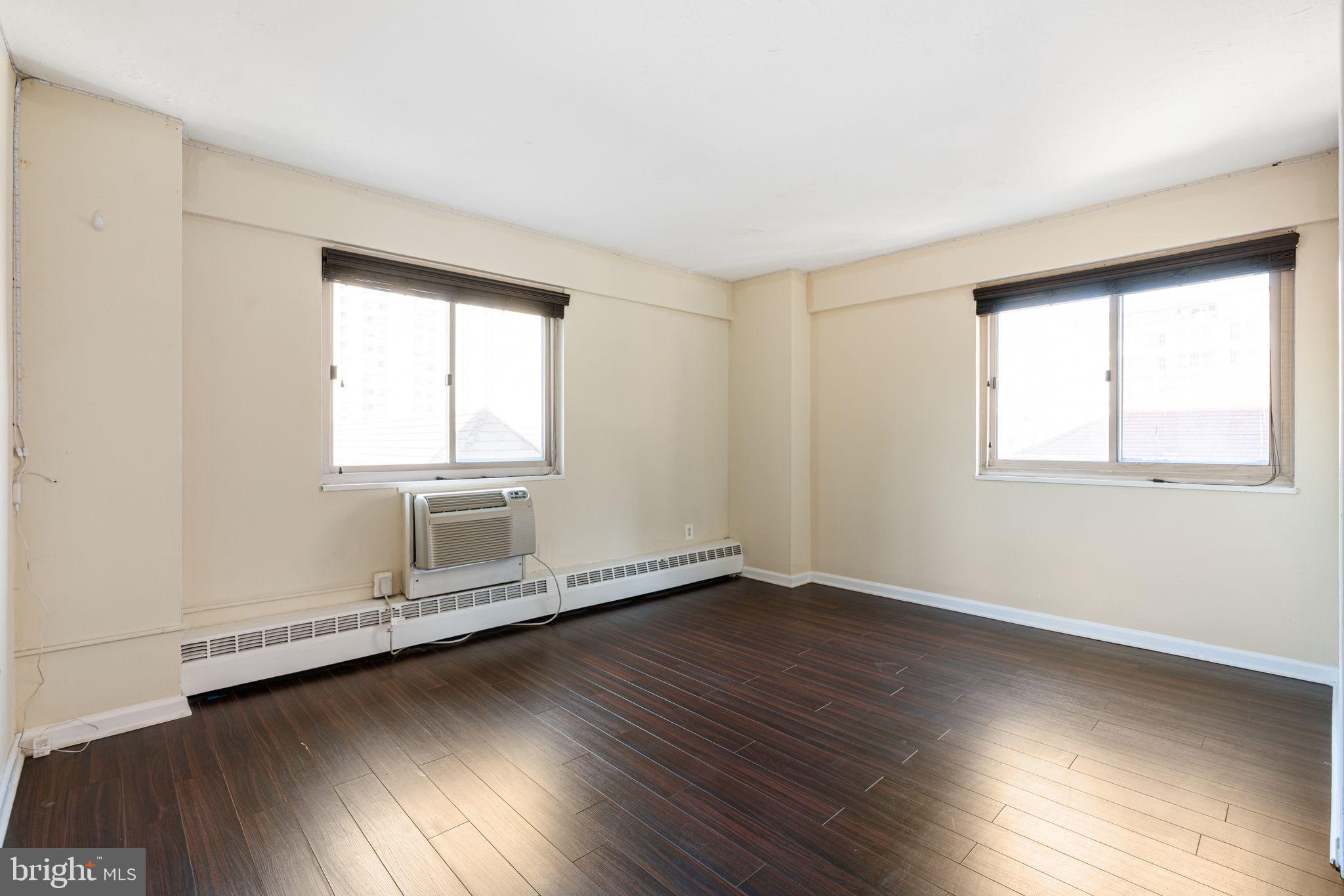2101-17 Chestnut Street, Unit 518 Philadelphia, PA 19103 - Photo 9 of 14 an empty room with wooden floor and windows