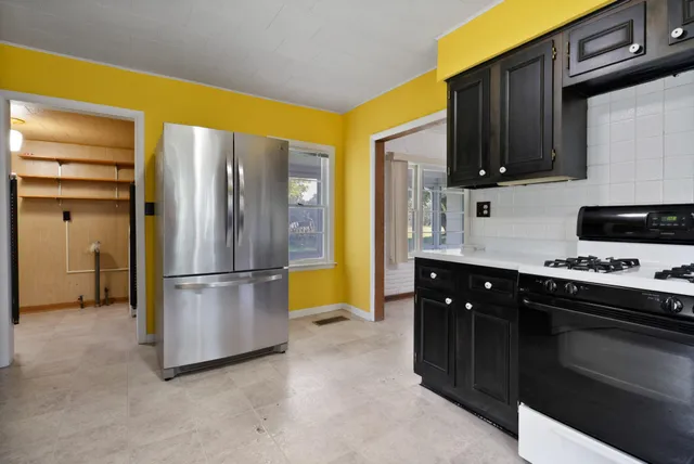a kitchen with stainless steel appliances granite countertop a refrigerator a stove a sink and a cabinets