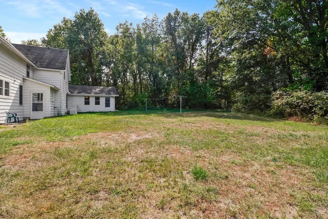 a view of a house with a yard and sitting area