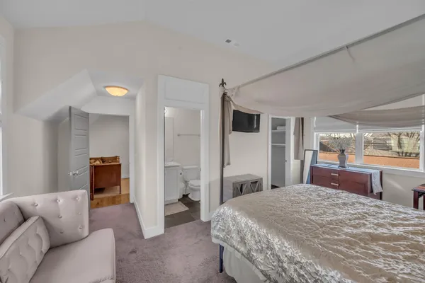 a bedroom with a large bed and wooden floor