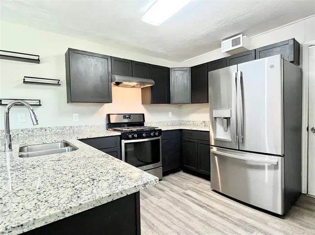 a kitchen with a refrigerator sink and stove