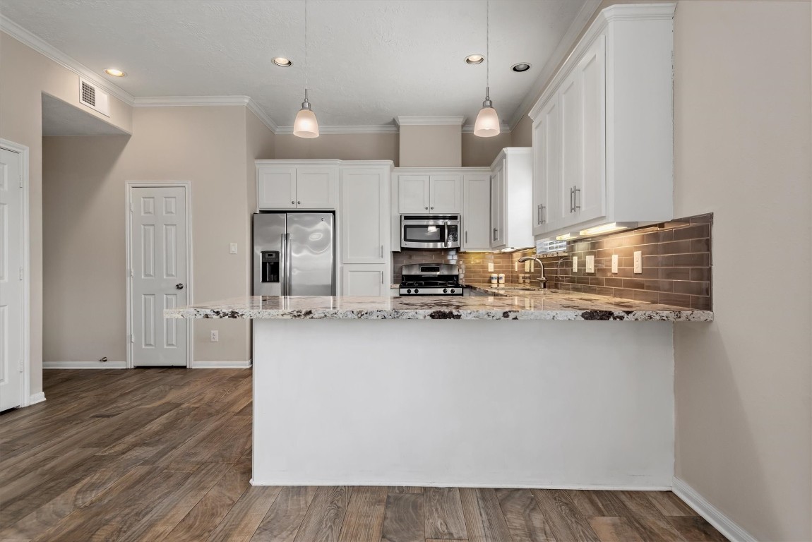 7036 West 43rd Street Houston, TX 77092 - Photo 12 of 28 a kitchen with kitchen island a sink appliances and cabinets