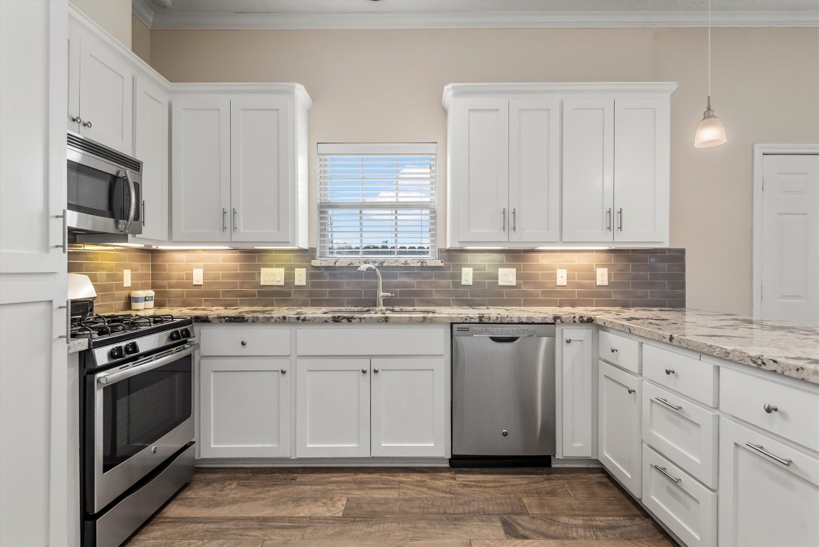 7036 West 43rd Street Houston, TX 77092 - Photo 14 of 28 a kitchen with granite countertop white cabinets and stainless steel appliances