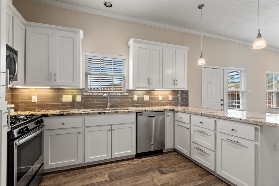 7036 West 43rd Street Houston, TX 77092 - Photo 16 of 28 a kitchen with granite countertop white cabinets and stainless steel appliances