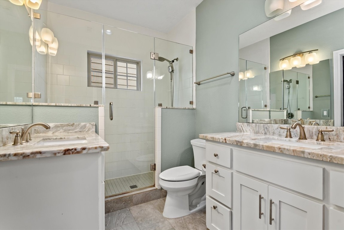 7036 West 43rd Street Houston, TX 77092 - Photo 20 of 28 a bathroom with a granite countertop sink a toilet and a mirror