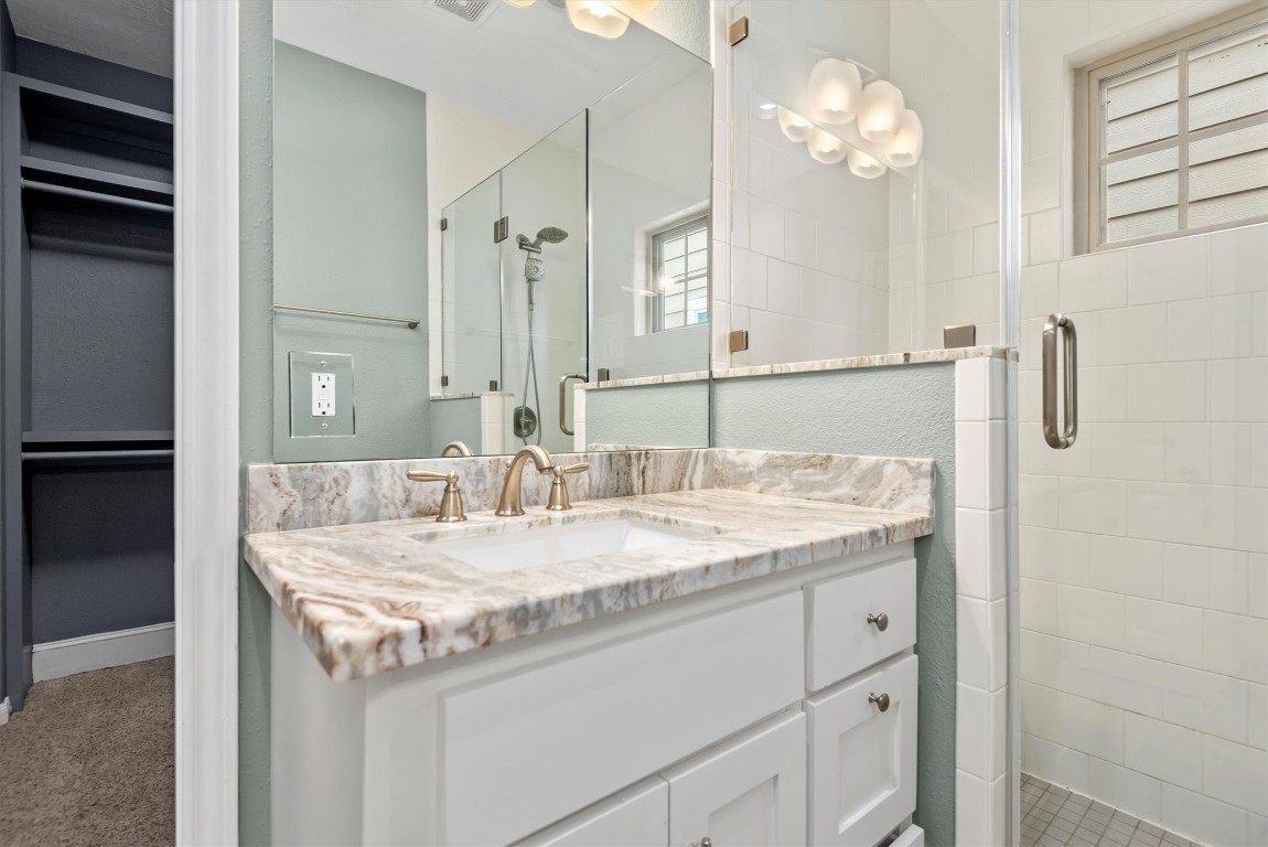 7036 West 43rd Street Houston, TX 77092 - Photo 21 of 28 a bathroom with a granite countertop sink a mirror and shower