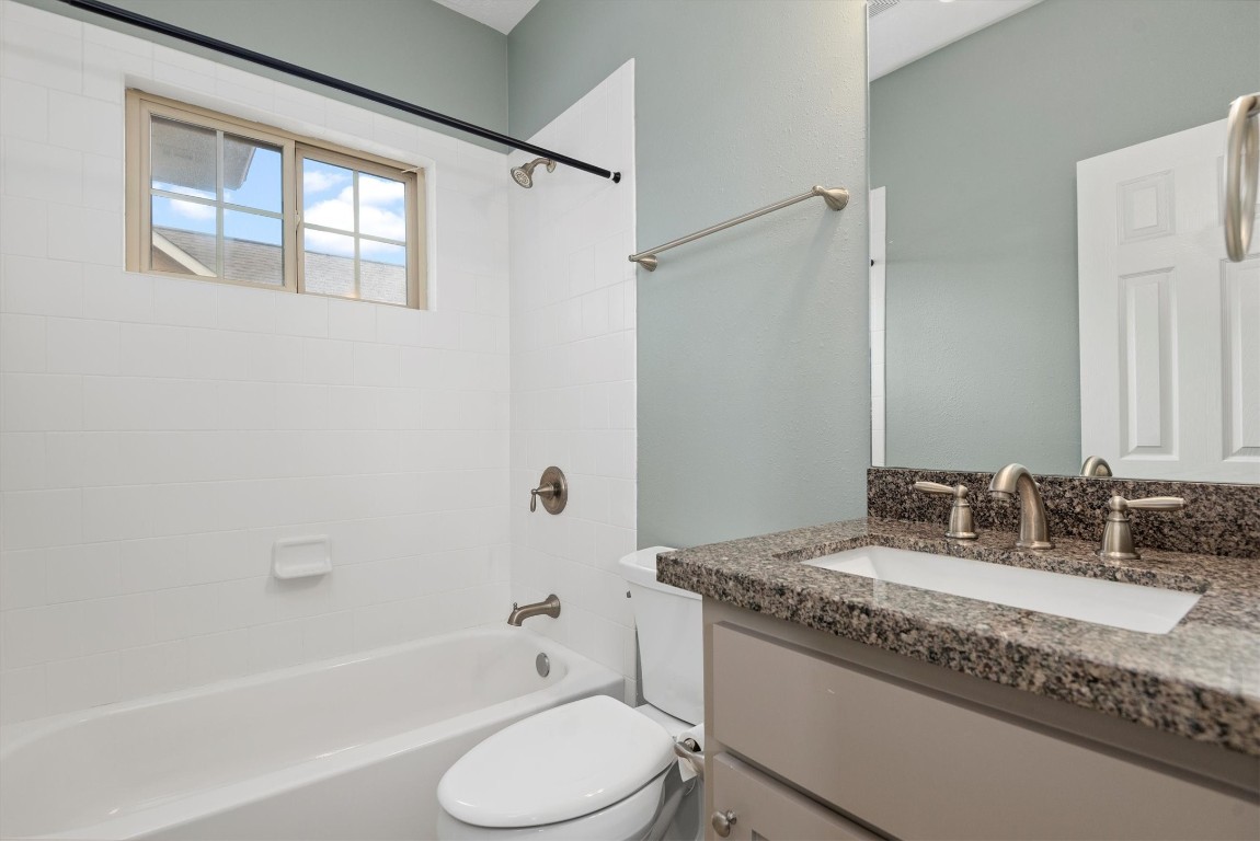 7036 West 43rd Street Houston, TX 77092 - Photo 26 of 28 a bathroom with a granite countertop sink toilet and shower
