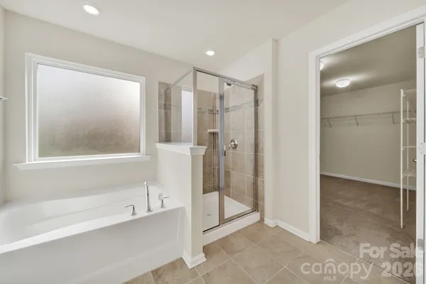 a bathroom with a glass shower door and a bathtub