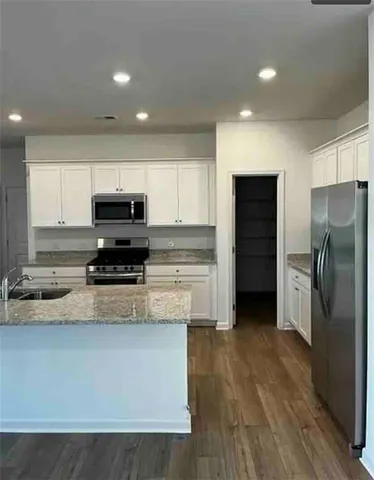 a kitchen with stainless steel appliances a refrigerator a stove a sink and a oven