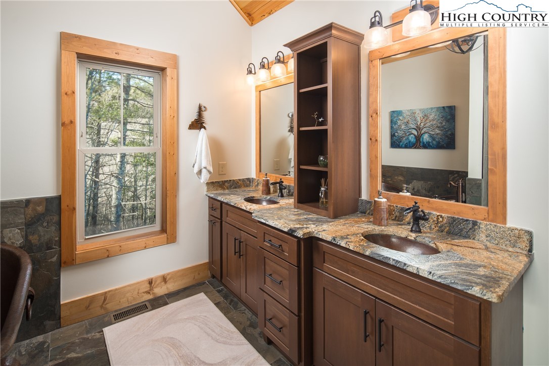 765 Pepperroot Road Boone, NC 28607 - Photo 18 of 35 a bathroom with a granite countertop sink and a window