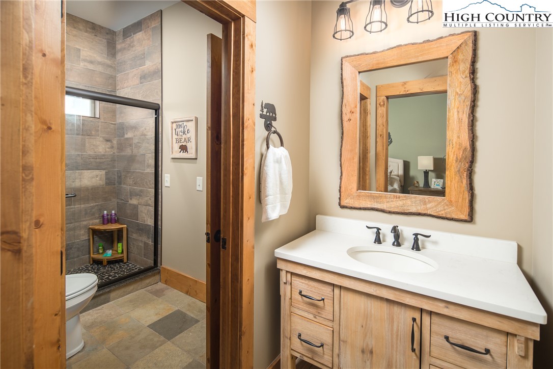 765 Pepperroot Road Boone, NC 28607 - Photo 26 of 35 a en suite bathroom with a sink a mirror and a shower