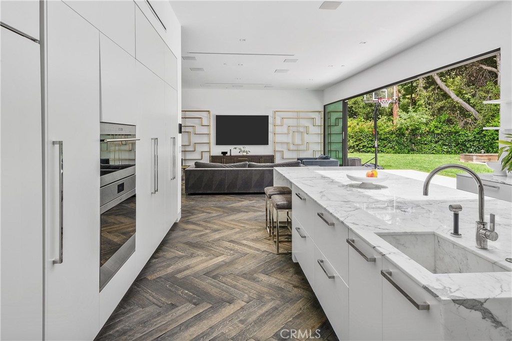 9924 Liebe Drive Beverly Hills, CA 90210 - Photo 30 of 65 a large kitchen with kitchen island granite countertop a large center island and a stove