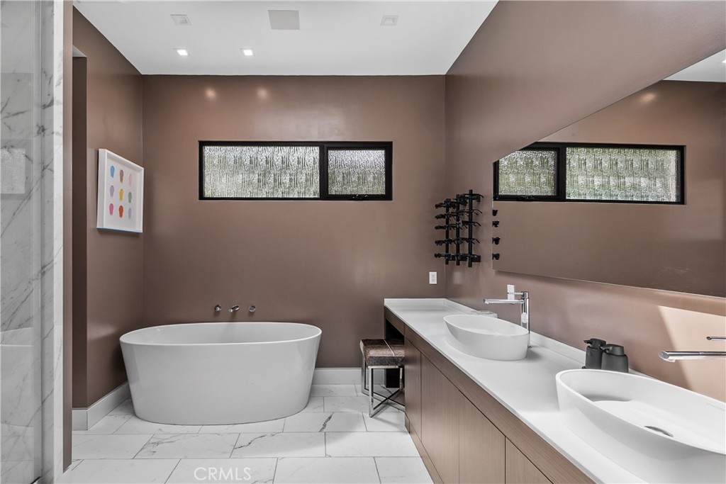 9924 Liebe Drive Beverly Hills, CA 90210 - Photo 34 of 65 a bathroom with a white tub a sink and mirror