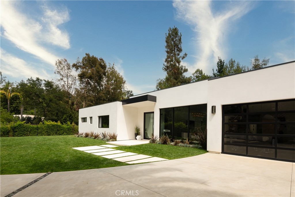 9924 Liebe Drive Beverly Hills, CA 90210 - Photo 6 of 65 a view of a white house in front of a yard with lawn chairs and a yard