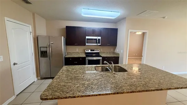 a kitchen with kitchen island a refrigerator stove and oven