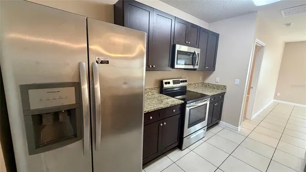 a kitchen with stainless steel appliances granite countertop a refrigerator and a sink