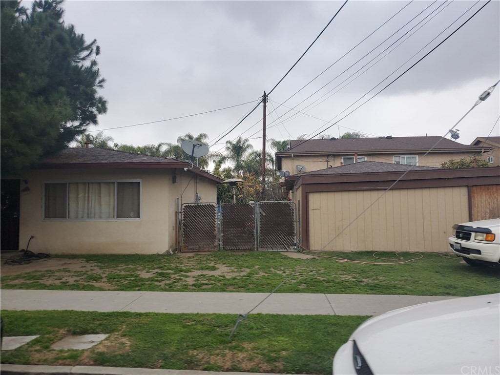 7913 Howe Street Paramount, CA 90723 - Photo 8 of 17 a front view of a house with a yard and garage
