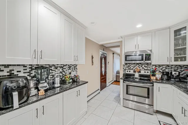 a kitchen with white cabinets and appliances