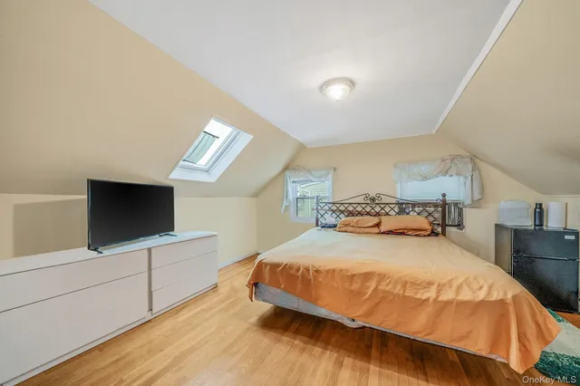 a bedroom with a bed and a flat tv screen on wall