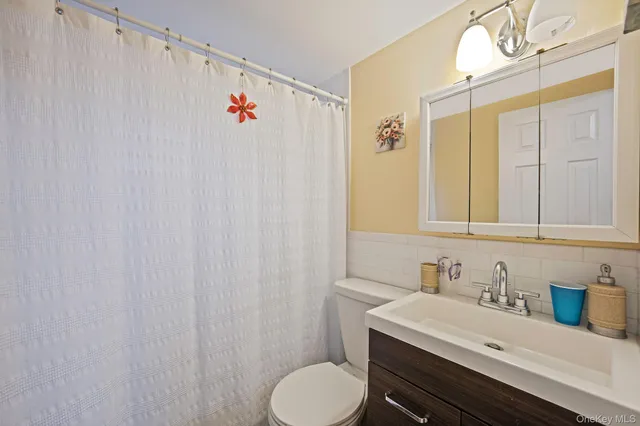 a bathroom with a sink vanity mirror and toilet