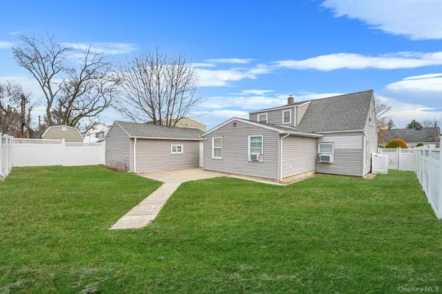 a view of a big house with a big yard and large trees